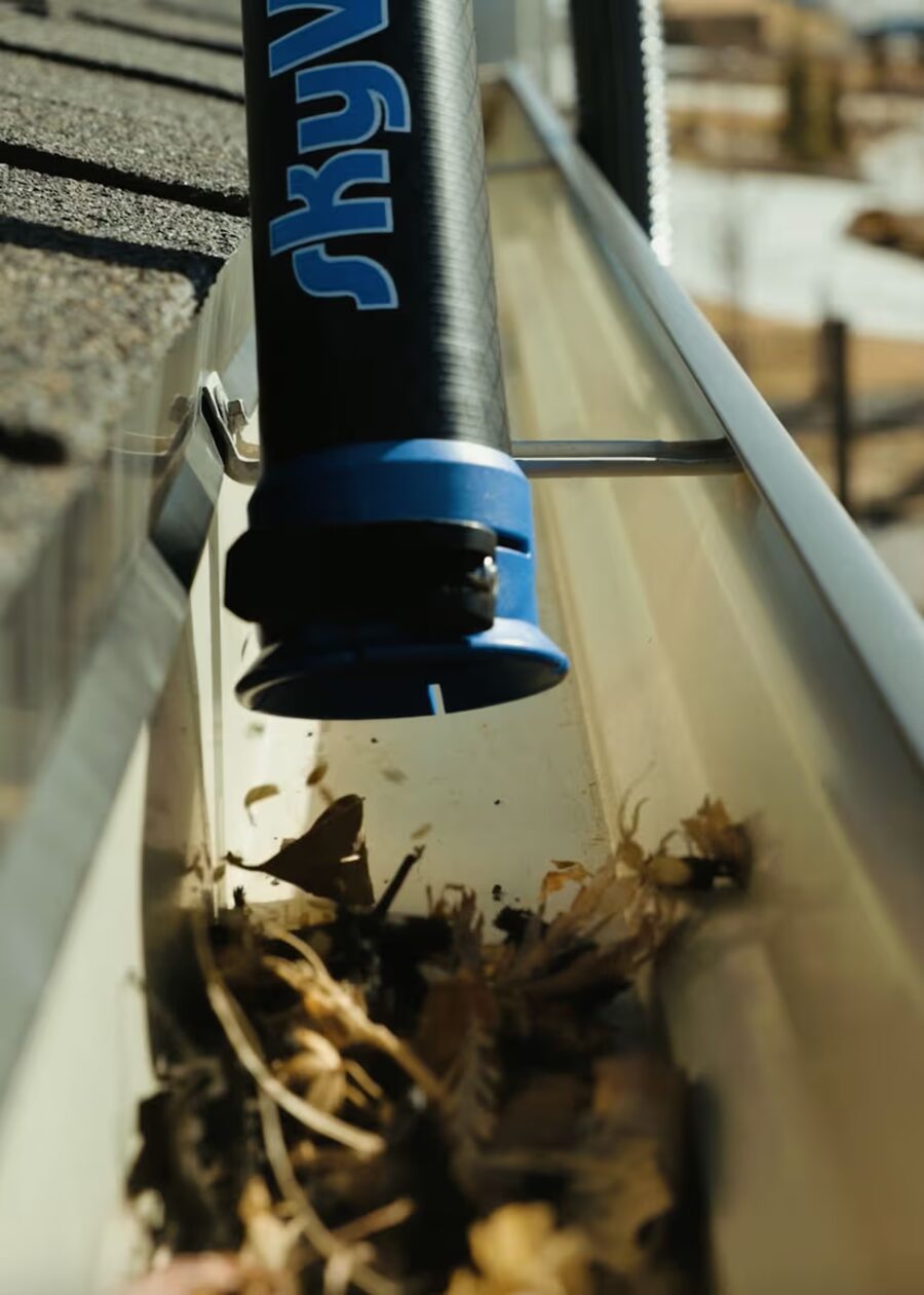Sterling Home Services gutter cleaning tool clearing leaves from a gutter