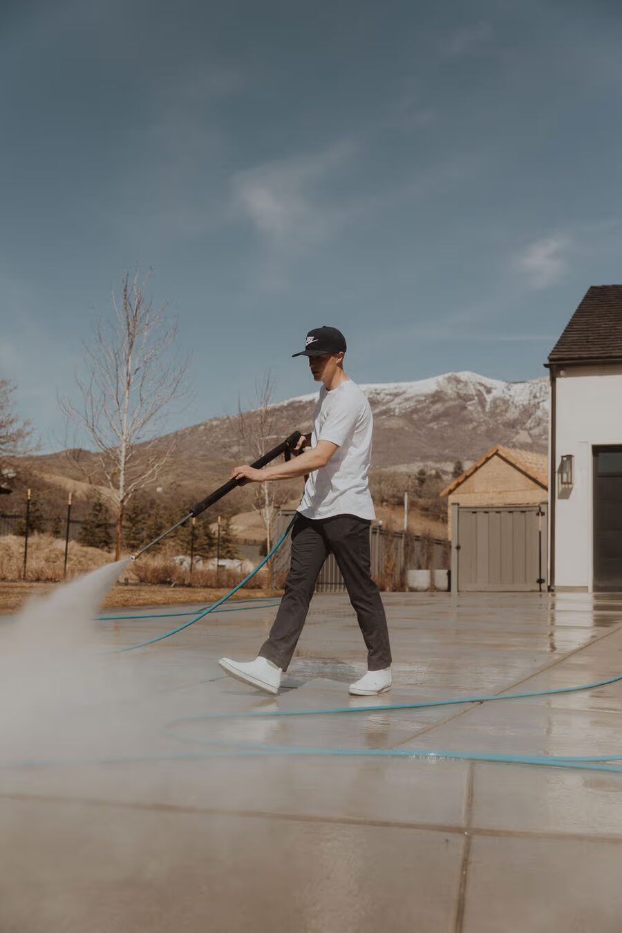 Sterling Home Services technician pressure washing a driveway